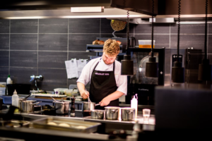 A chef whisking a sauce for a customer’s meal.