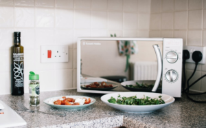 A microwave on the countertop with two ceramic plates in front of it