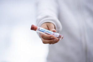 A doctor holding a COVID19 test sample inside a healthcare facility.